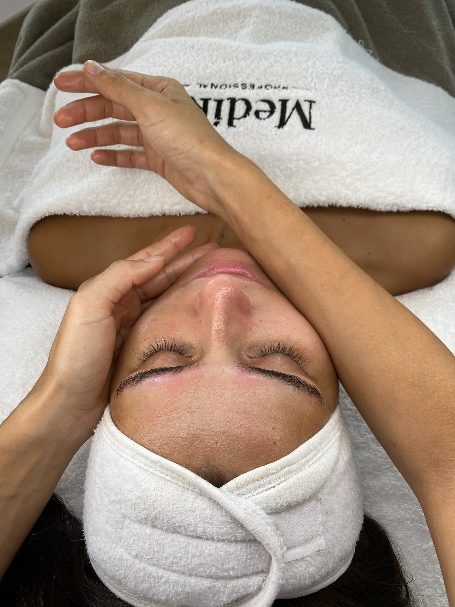 klant liggend op behandeltafel klaar voor gezichtsmassage