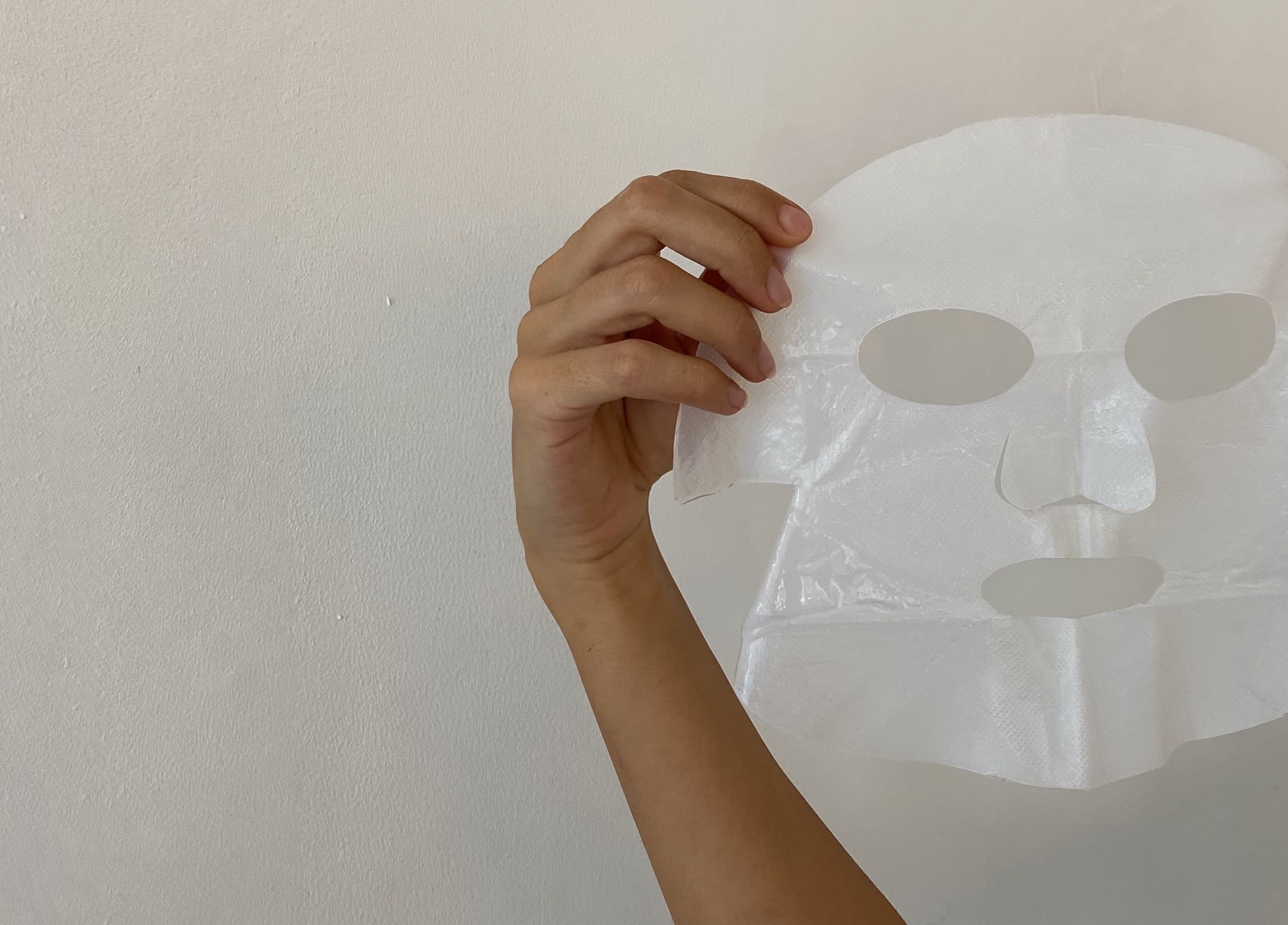 close up van een gezichtsmasker dat met een hand wordt omhoog gehouden